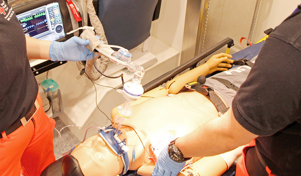 Notfallsanitäterschüler bei einer Reanimationsübung einer Puppe im Simulations-RTW