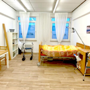 RETTcampus Trainingsareal in einem Pflegezimmer mit Krankenbett, Rollator und Gehhilfe
